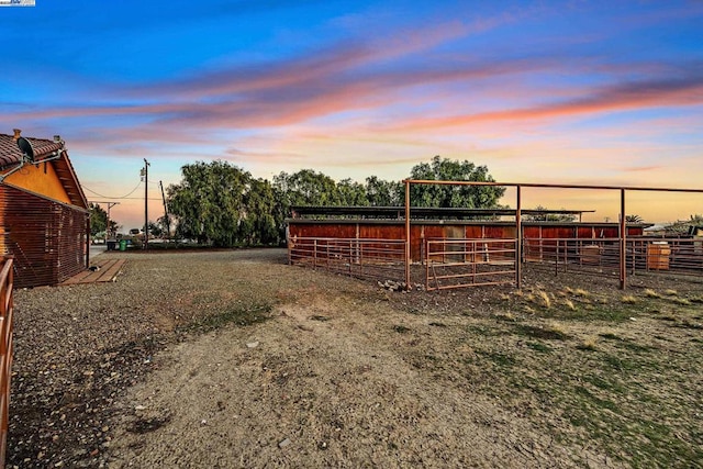 yard at dusk featuring an outbuilding