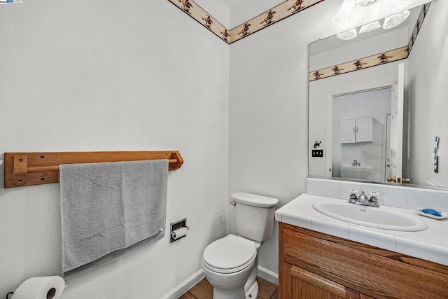 bathroom featuring tile patterned floors, toilet, and vanity