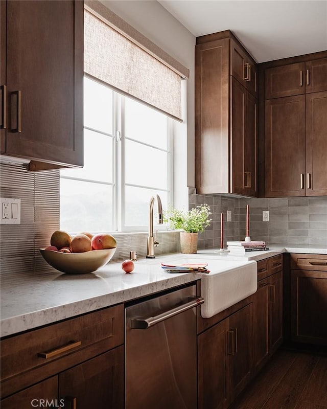 kitchen with decorative backsplash, dark wood-type flooring, stainless steel dishwasher, and dark brown cabinets