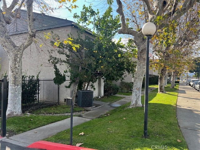 exterior space featuring central AC unit and a yard