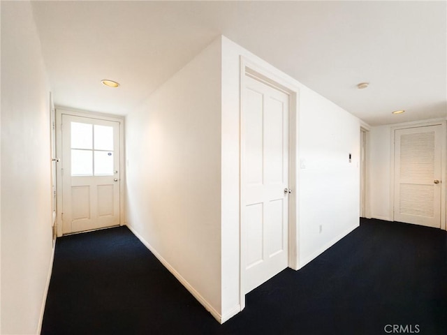 hallway with dark colored carpet