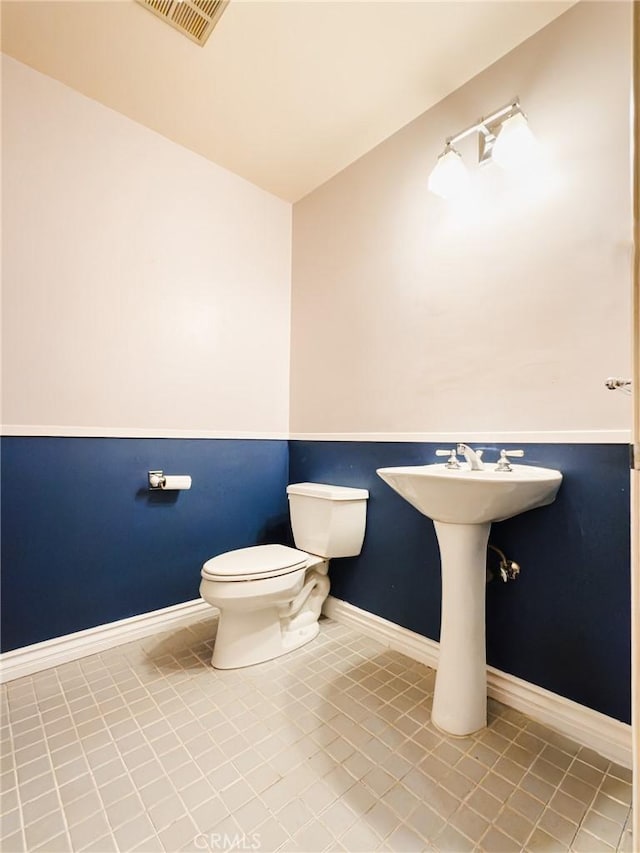 bathroom with toilet and tile patterned flooring