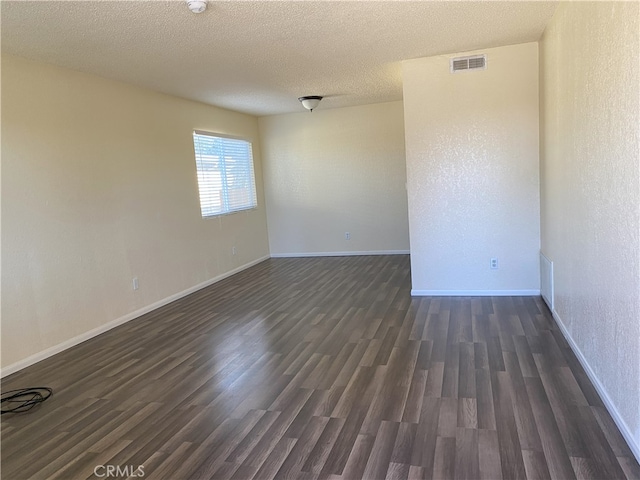 unfurnished room with a textured ceiling and dark hardwood / wood-style floors