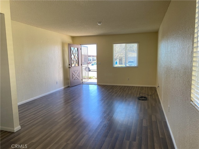 unfurnished room with dark hardwood / wood-style floors and a textured ceiling