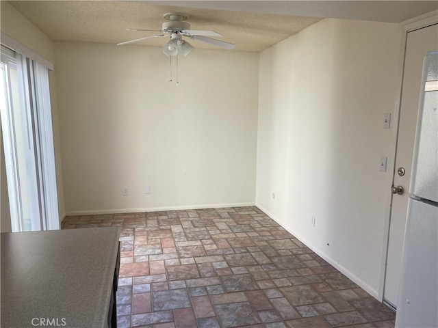 empty room featuring ceiling fan and a textured ceiling