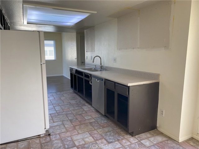 kitchen featuring stainless steel dishwasher, sink, and white fridge