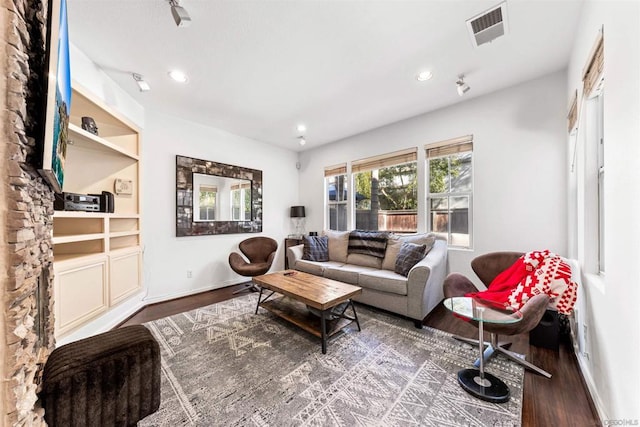 living room featuring built in features and dark hardwood / wood-style floors