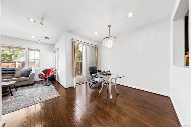 dining area with a notable chandelier and dark hardwood / wood-style flooring