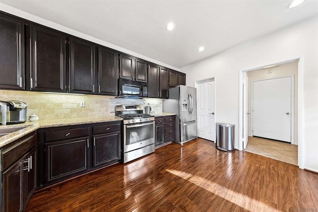 kitchen featuring dark wood-type flooring, stainless steel appliances, dark brown cabinets, and backsplash