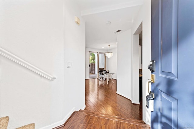 entrance foyer with dark hardwood / wood-style flooring and a notable chandelier