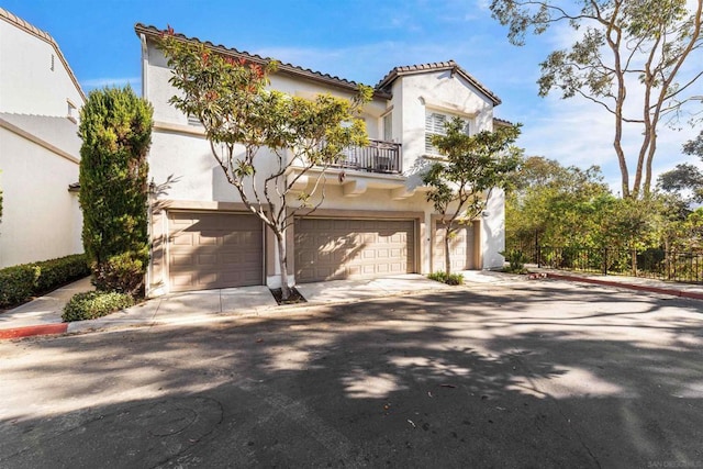 mediterranean / spanish house with a garage and a balcony