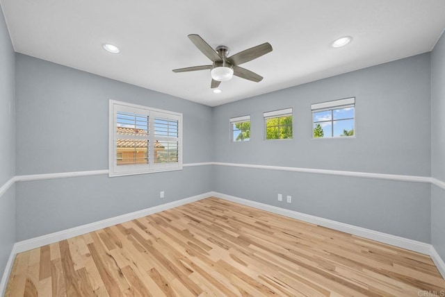 empty room with ceiling fan and light hardwood / wood-style flooring