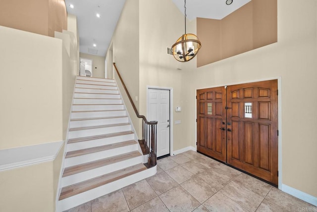 tiled entrance foyer with a notable chandelier and a high ceiling