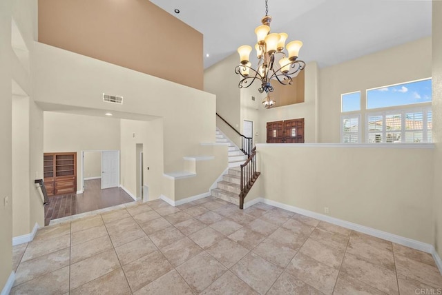 tiled entryway with a chandelier and a high ceiling