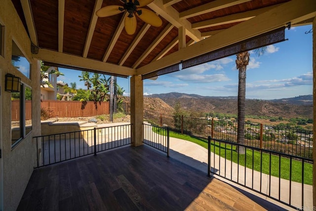 wooden terrace featuring ceiling fan and a mountain view