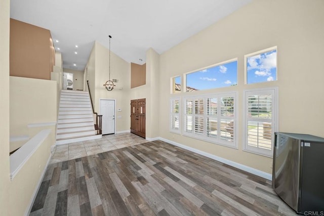 foyer entrance featuring a notable chandelier, a high ceiling, and hardwood / wood-style flooring