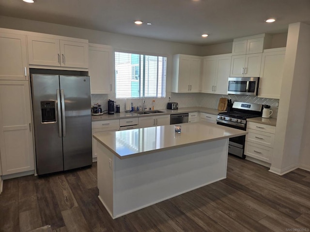 kitchen with white cabinetry, appliances with stainless steel finishes, dark hardwood / wood-style floors, and a kitchen island