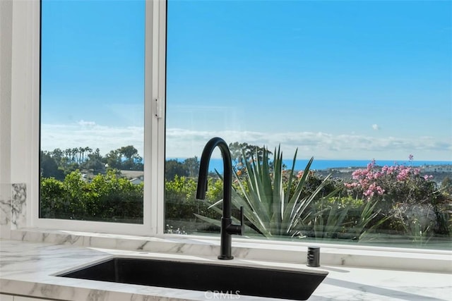 interior details with light stone countertops and sink