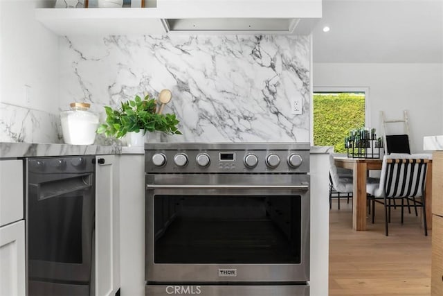 kitchen with backsplash, hardwood / wood-style floors, range, and ventilation hood