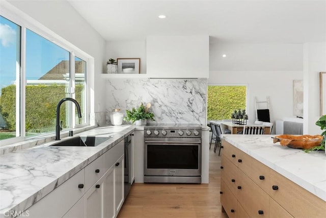 kitchen featuring decorative backsplash, sink, light stone countertops, appliances with stainless steel finishes, and white cabinets