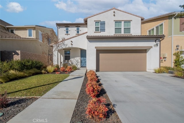 mediterranean / spanish-style home featuring a front yard and a garage