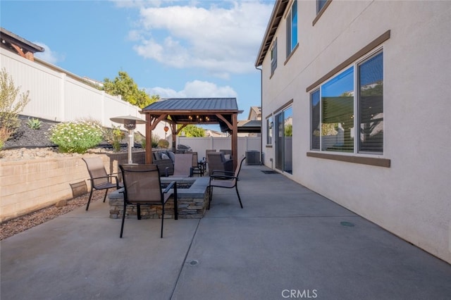 view of patio featuring central AC, a gazebo, and an outdoor fire pit