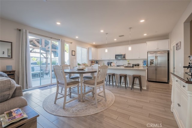 dining space with light hardwood / wood-style flooring