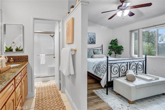 bedroom with ceiling fan, sink, light hardwood / wood-style flooring, and a closet