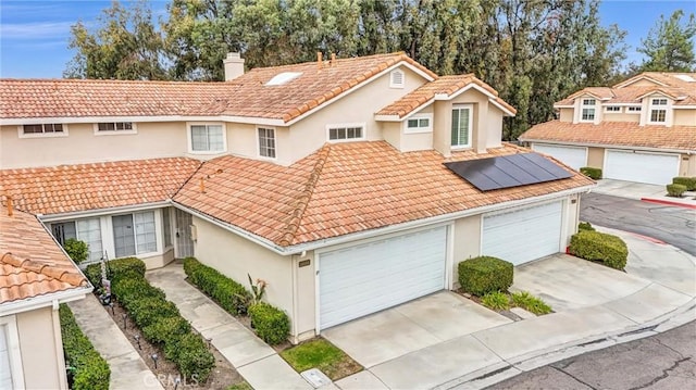 view of front facade featuring a garage and solar panels