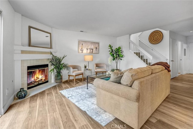 16096 Caminito Tomas, San Diego, CA 92128 - living room featuring a tile fireplace, wood finished floors, and stairs
