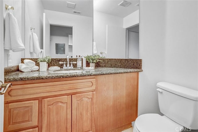 bathroom featuring toilet and vanity