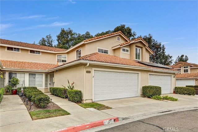 16096 Caminito Tomas, San Diego, CA 92128 - townhome / multi-family property featuring concrete driveway, a tiled roof, stucco siding, solar panels, and an attached garage