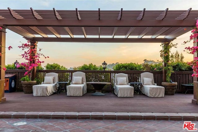 patio terrace at dusk with a deck and a pergola