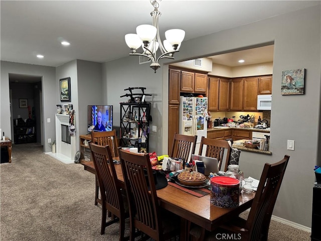 dining room featuring light carpet and an inviting chandelier