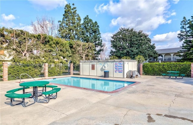 pool with a patio area and fence