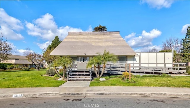 view of front of home featuring stairway and a front lawn