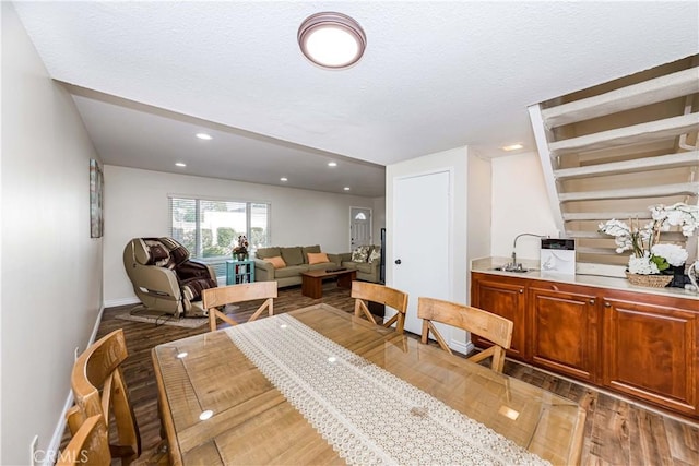 dining space featuring recessed lighting, a textured ceiling, baseboards, and wood finished floors