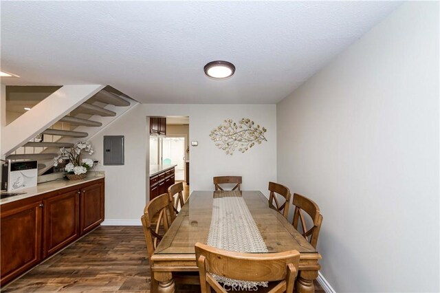 dining area featuring dark wood-style floors, electric panel, baseboards, and a textured ceiling