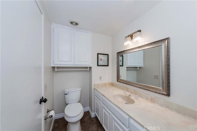 bathroom featuring toilet, tile patterned flooring, baseboards, and vanity