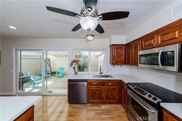 kitchen featuring light countertops, appliances with stainless steel finishes, a sink, and visible vents