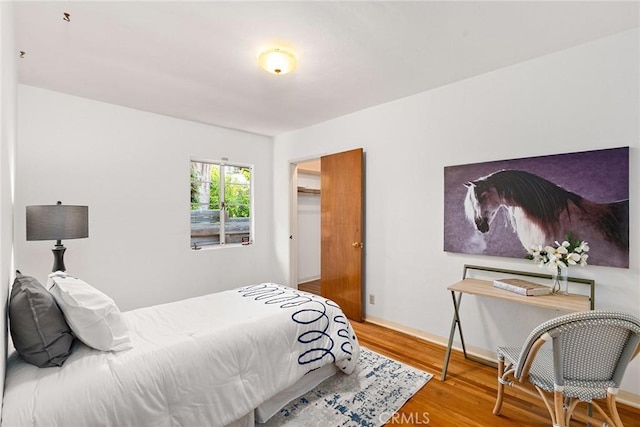 bedroom with wood-type flooring and a closet