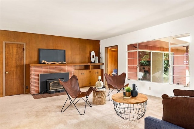 living room with light colored carpet, wood walls, and a wood stove