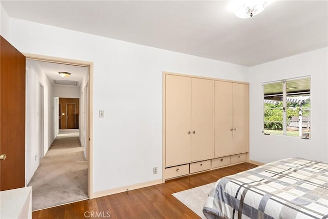 bedroom with light hardwood / wood-style floors and a closet