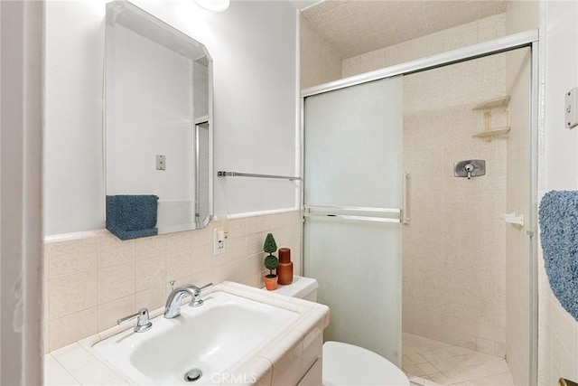 bathroom with toilet, tile walls, a shower with shower door, and backsplash