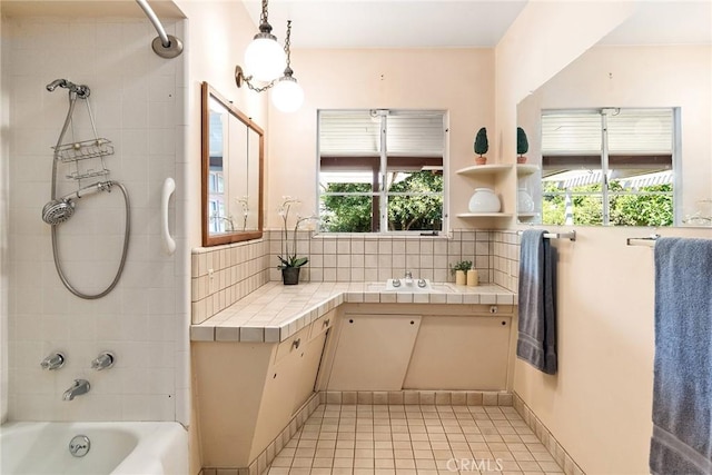 bathroom featuring tile patterned floors, vanity, tiled shower / bath combo, and tasteful backsplash