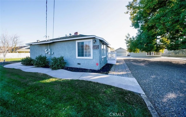 view of side of property featuring a lawn, an outdoor structure, and a garage