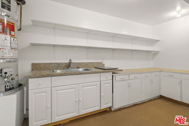 kitchen with sink, white cabinetry, and gas water heater