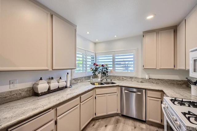 kitchen featuring light stone counters, sink, white appliances, and light hardwood / wood-style floors