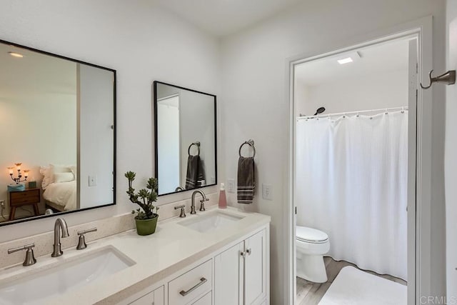 bathroom featuring toilet, hardwood / wood-style flooring, and vanity