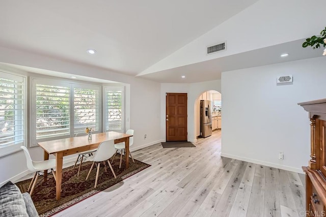 dining area featuring light hardwood / wood-style flooring and vaulted ceiling